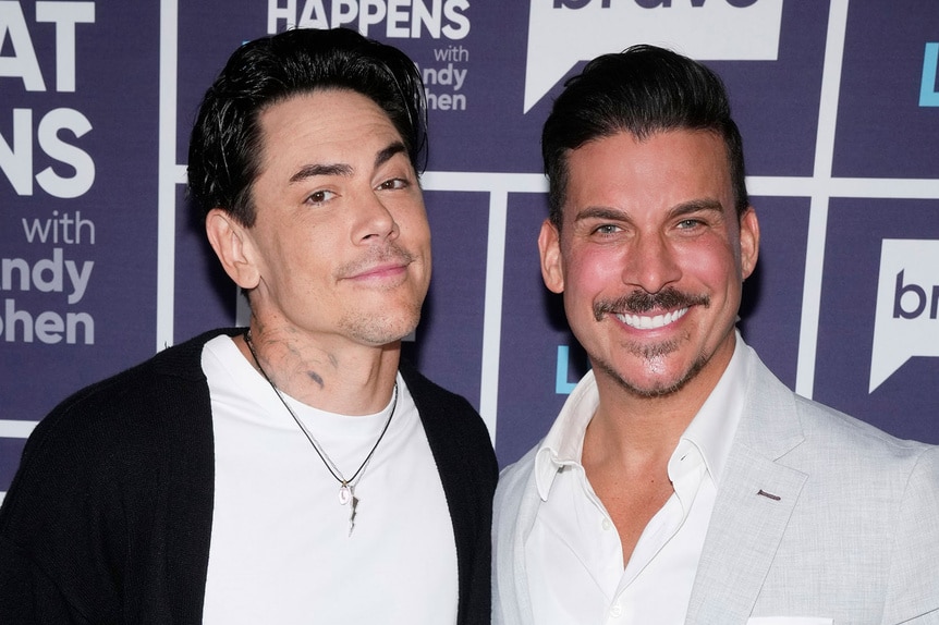 Tom Sandoval and Jax Taylor standing in front of the WWHL step and repeat