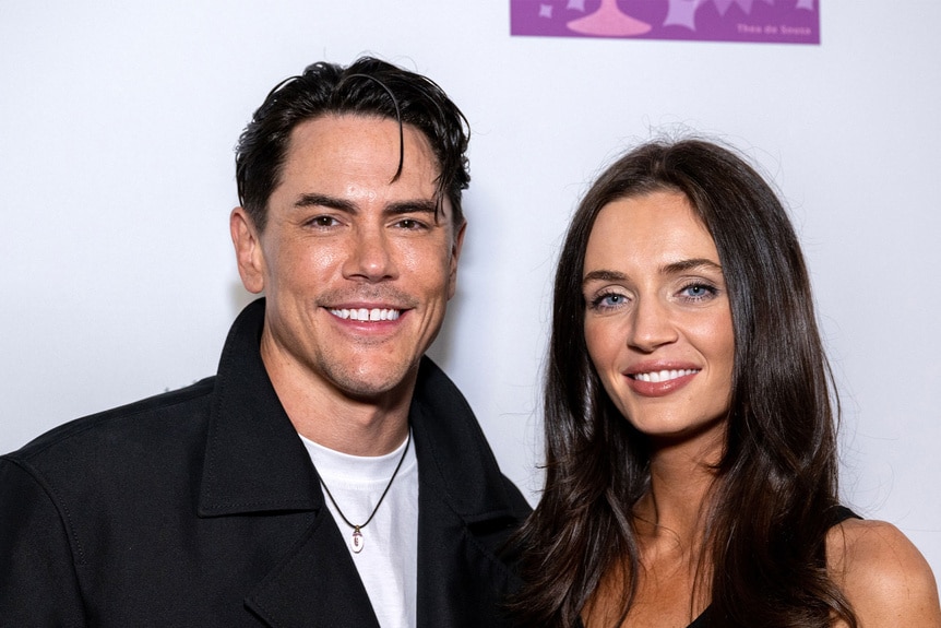 Tom Sandoval and Victoria Lee Robinson posing in front of a step and repeat.