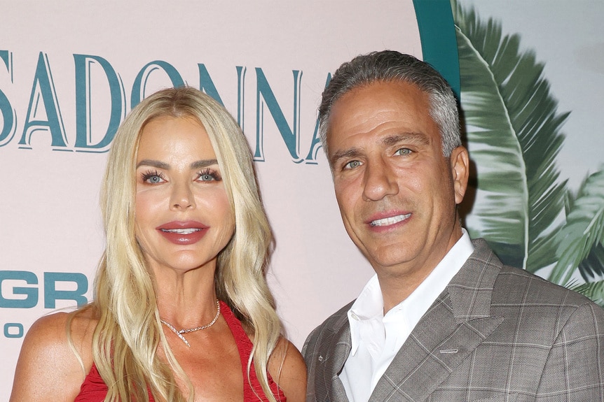 Alexia Nepola and Todd Nepola posing in front of a step and repeat.