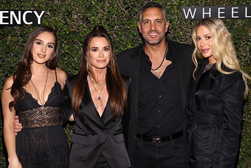 Kyle Richards, Mauricio Umansky, Dorit Kemsley, and Alexia Umansky posing together in front of a step and repeat.