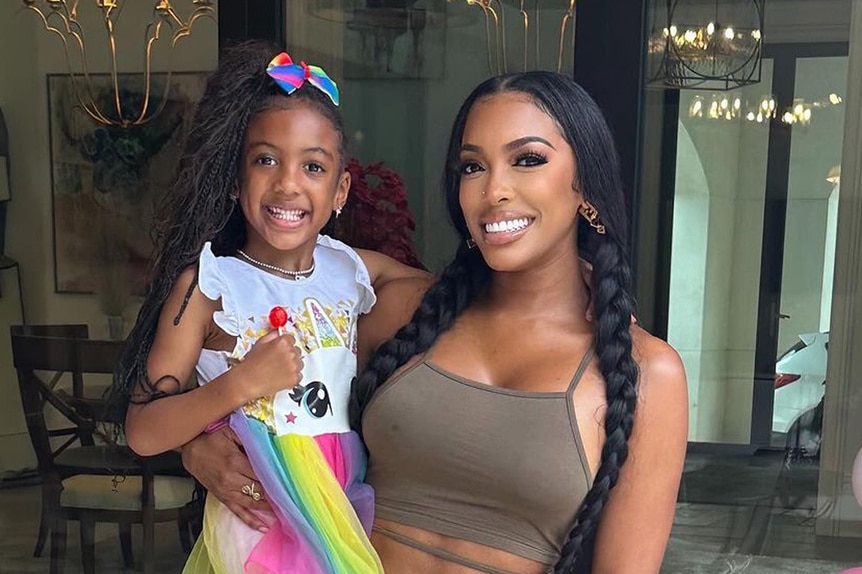 Porsha Williams carrying her daughter Pilar Jhena on her outside patio