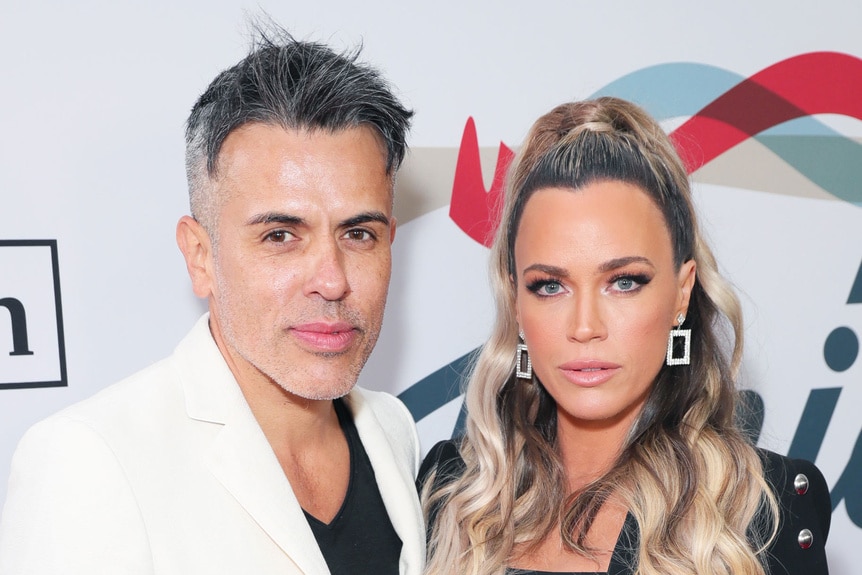 Teddi Mellencamp and Edwin Arroyave posing in front of a step and repeat.