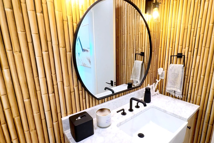 A bathroom vanity with bamboo wall decor