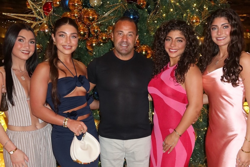 Joe Giudice poses with his daughters in front of a Christmas tree in the Bahamas