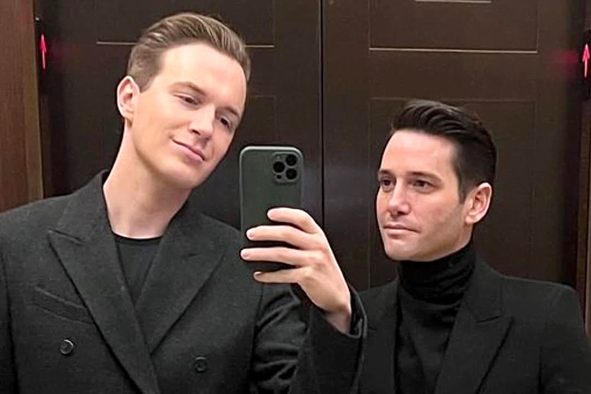 Josh Flagg wearing a black turtleneck and blazer with Kelton also wearing a black blazer