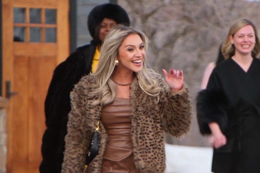 Sarah Martindale wearing a leapord print jacket while waving outside