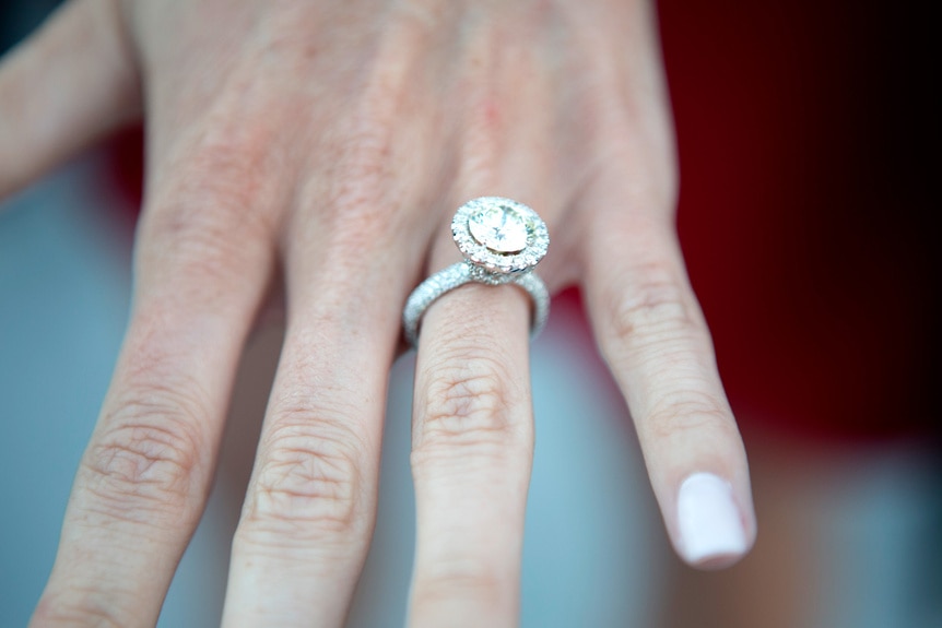 A close up of Heather Bilyeu's diamond engagement ring on her hand on MDLLA